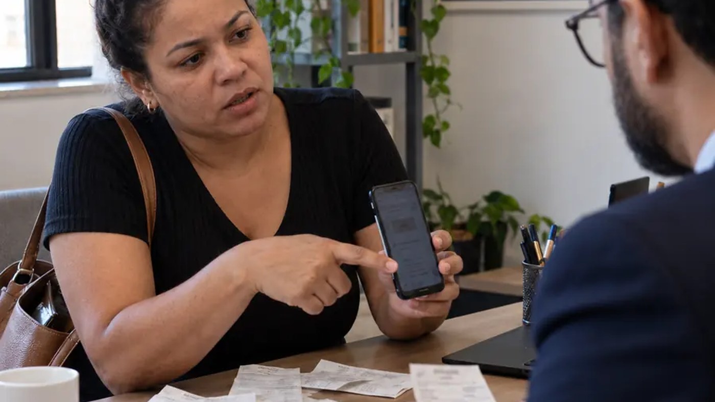 Mulher analisando documentos e recibos sobre a mesa